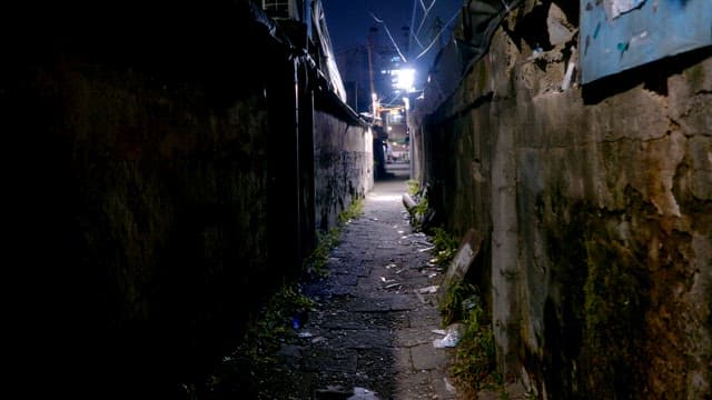 Narrow alleyway at night with dim lighting