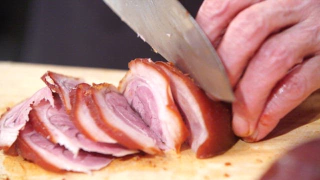 Cutting braised pigs' feet on a board