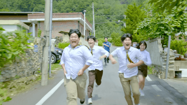 High school students running and laughing in a countryside alley on a sunny day
