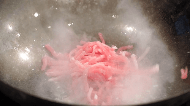 Sliced pork cooking in a hot pan
