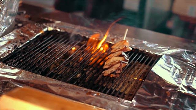 Delicious grilled skewers on a flaming grill