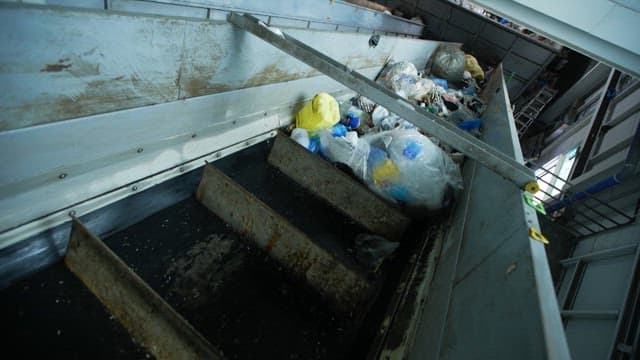Conveyor belt transporting various waste materials indoors