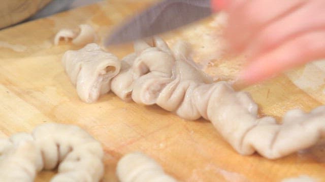 Cutting pork intestines on a wooden board