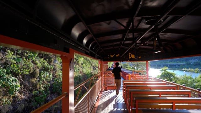 Man walking inside a renovated old train on a sunny day