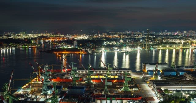 Night view of a shipyard in Ulsan with city lights and cranes and ships at night