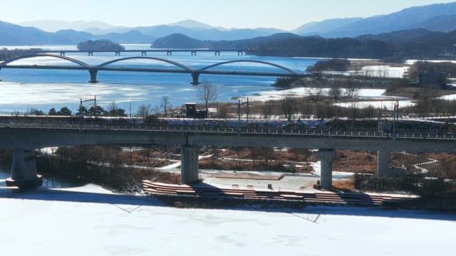 Snowy Landscape with Bridges Over Frozen River