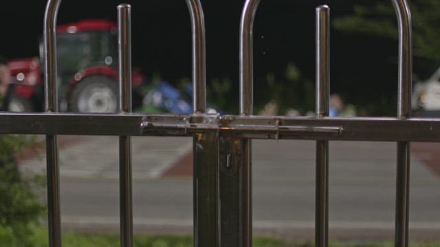 Man wandering in front of an iron gate at night