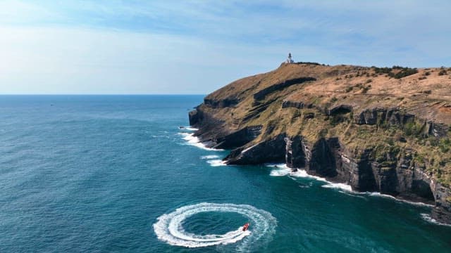 Lighthouse on a cliff by the sea