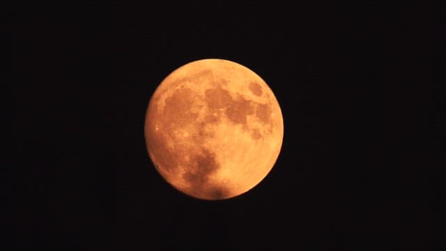Full moon in the night sky with detailed surface visible