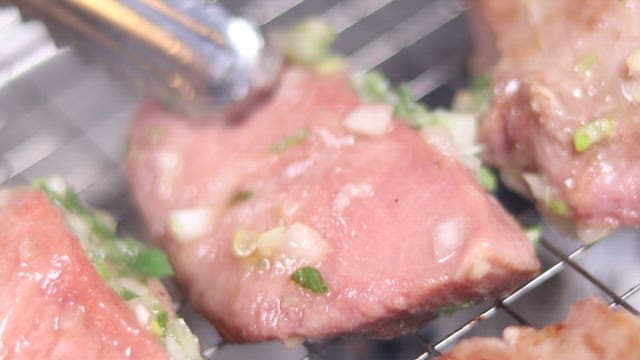 Sizzling Meat on a Smoky Grill