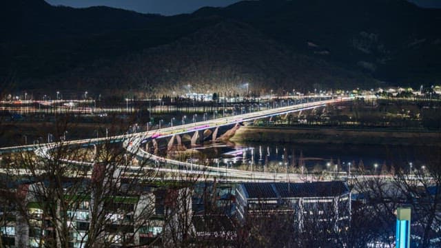 Night View Illuminated by the Lights of Traffic on the Bridge from Bustling City