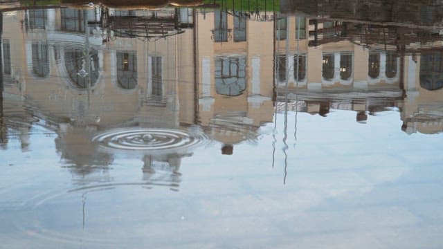 Reflections of buildings in a rain puddle