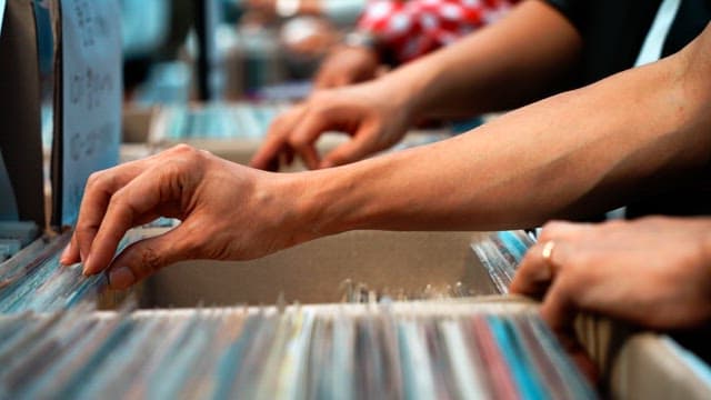 Hands browsing through vinyl records