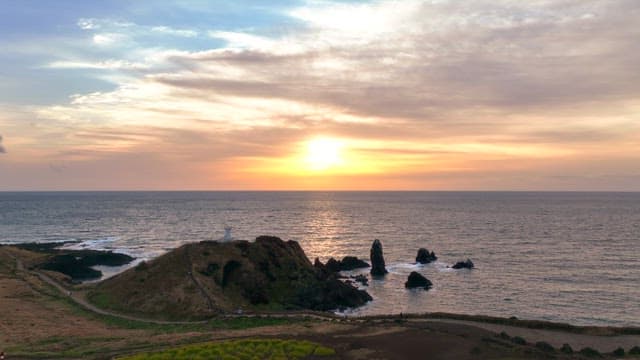 Sunset over the ocean with rocky cliffs