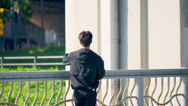 Man standing by a railing outdoors