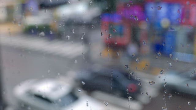 Raindrops on a window overlooking a city street