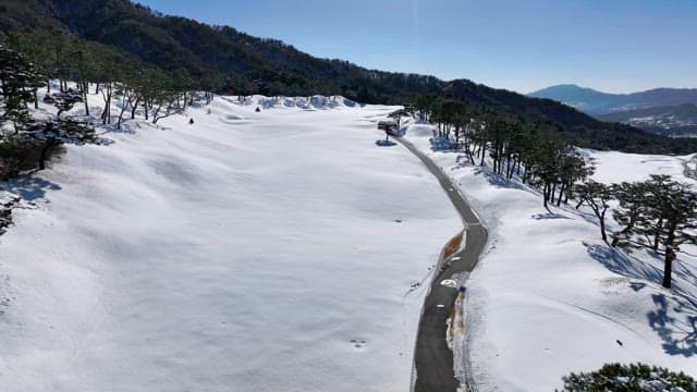 Snow-covered Landscape with Winding Road