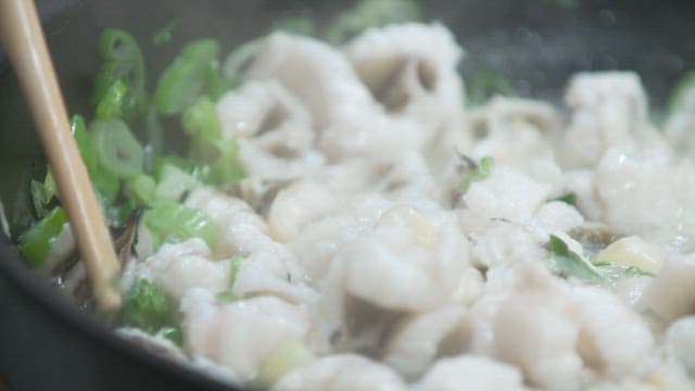 Conger eel and vegetables cooking in a frying pan