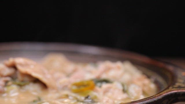 Spoonful of rice with pork soup in a pot