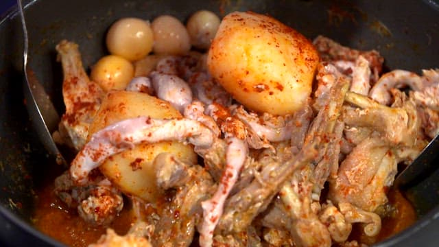Mixing spicy braised chicken with seasoning