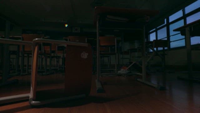 Dark Classroom Where Desks and Chairs Fall Over