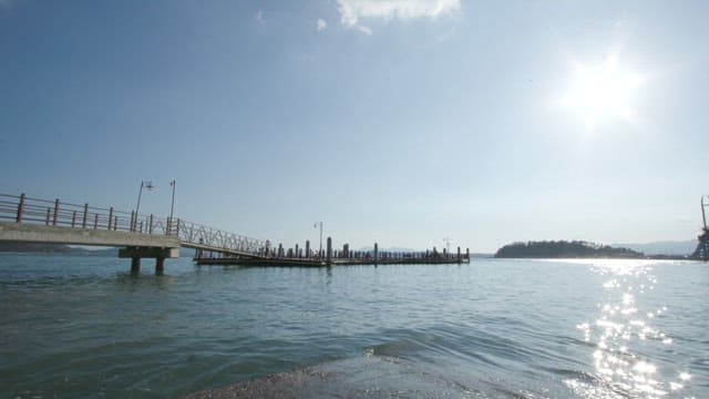 Serene Seaside with Pier and Bright Sun