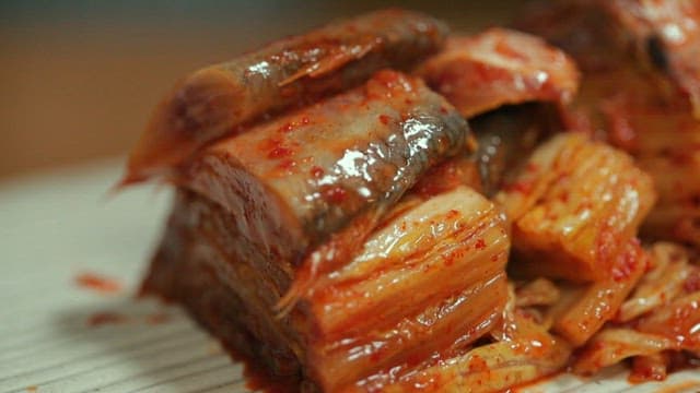 Kimchi with large-eyed herring being prepared on a wooden board