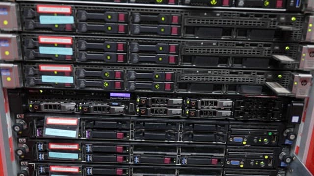 Multiple server racks with various labels and lit indicators in a data center server room