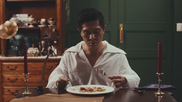 Man in a white shirt dining alone