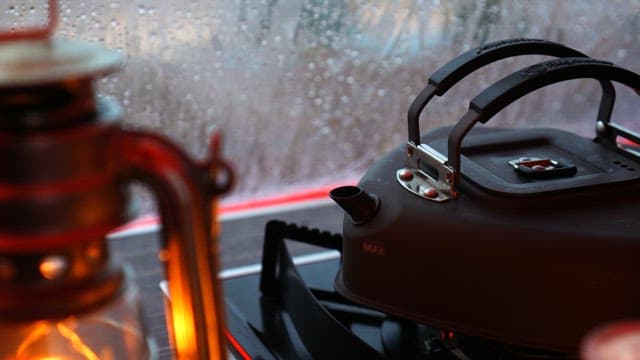 Black kettle boiling water on a rainy day