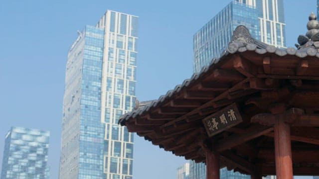 Traditional pavilion against modern skyscrapers on a clear day
