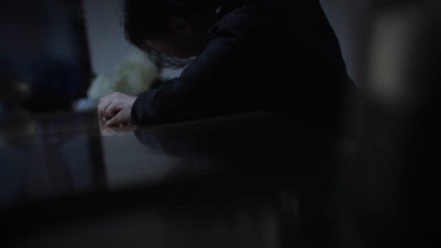 Dimly lit room with a person deep in thought