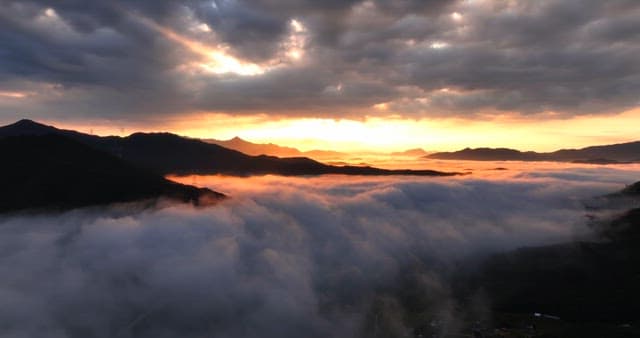 Sunrise over misty mountains with clouds