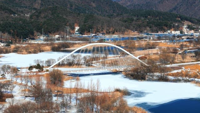 Snow-covered Park with Arched Bridge