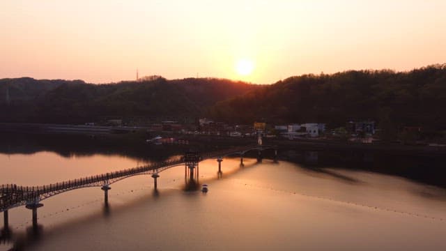 Scenic bridge over a calm river at sunset