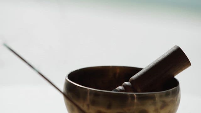 Tibetan singing bowl with an incense stick burning alongside