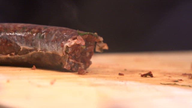 Sundae being sliced on a wooden board with knife