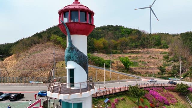 Lighthouse and wind turbines on a coastal hill