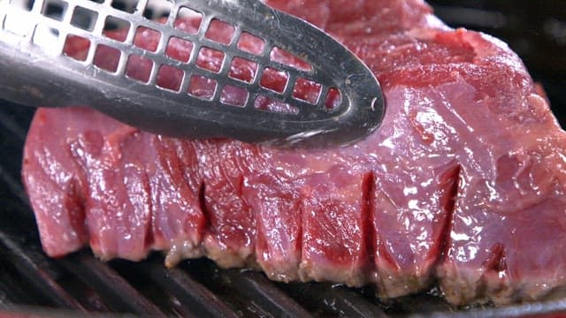 Grilling a juicy beef steak on a hot pan