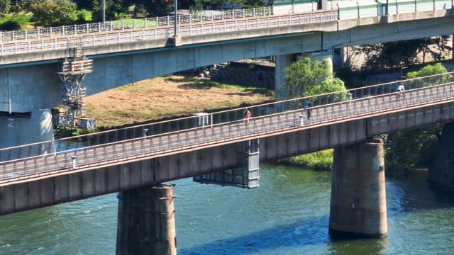 Cyclist and pedestrian on a bridge