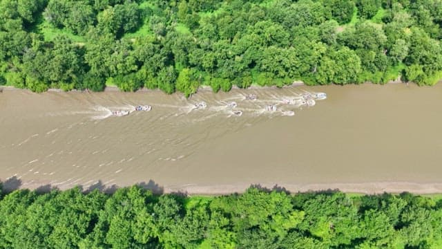 Boats cruising down a river on a sunny day