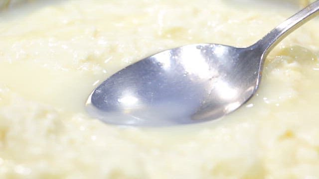 Spoonful of clear and white tofu stew broth