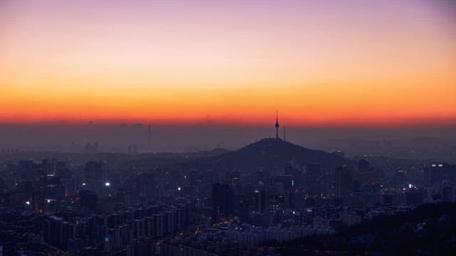 Sunrise over a city skyline with mountains in the background