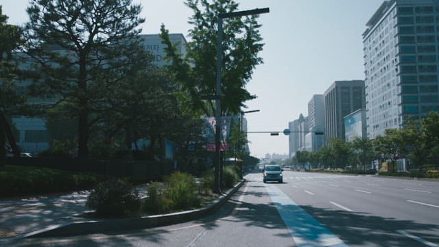 Car driving through a city street in daylight, entering national police agency