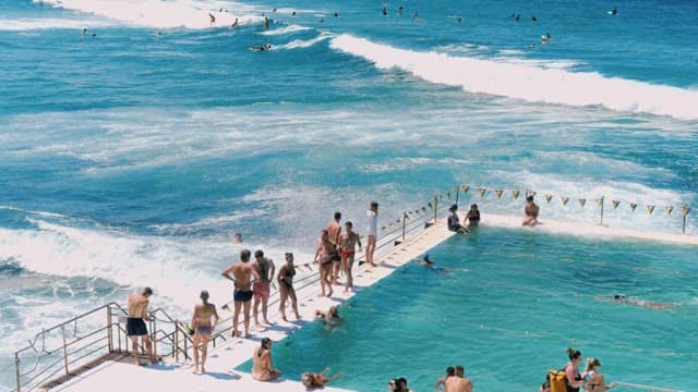 Busy Seaside Pool with Swimmers and Surfers