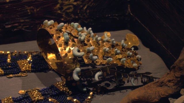 Ancient golden jewelry displayed under dim light