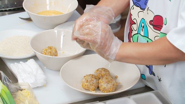 Making rice balls wearing vinyl gloves in the kitchen