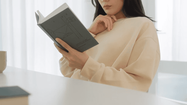 Woman Reading a Book in a Bright Room