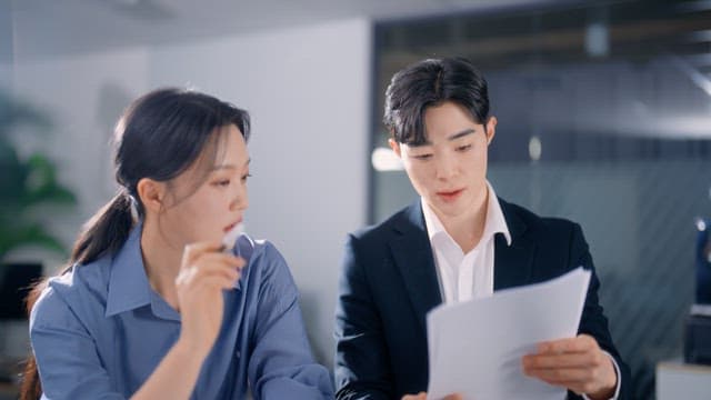 Two colleagues discussing documents