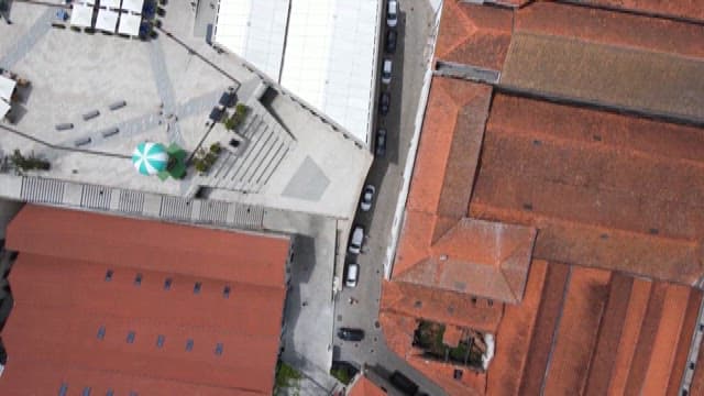 Cars Parked on the Street Between Red Roof Bildings